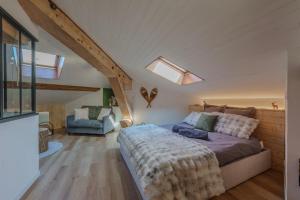 a bedroom with a bed and a chair in a attic at La grande Sure & Spa in Voiron