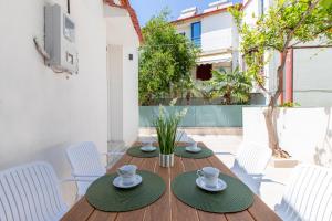 a wooden table with white chairs and cups on it at Casa Lili in Platanias
