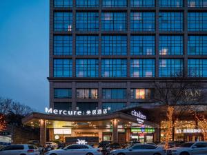 a large building with cars parked in front of it at Mercure Beijing City Center in Beijing