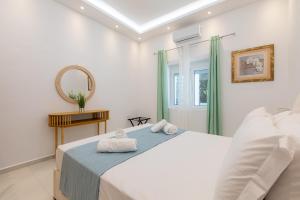 a white bedroom with a bed and a mirror at Casa Lili in Platanias +28 photos