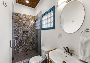 a bathroom with a shower and a toilet and a sink at Blue Heron Cottage in Galveston +54 photos