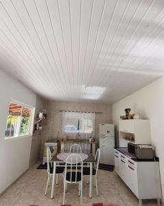 a kitchen with a table and chairs and a refrigerator at Casa amarela in Gonçalves