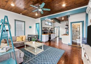 a living room with a ceiling fan and a table at Blue Heron Cottage in Galveston
