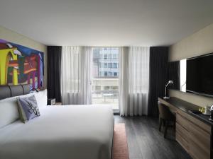 a hotel room with a bed and a flat screen tv at Mondrian Mexico City Condesa in Mexico City