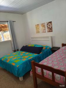 a bedroom with two beds and a window at Casa amarela in Gonçalves