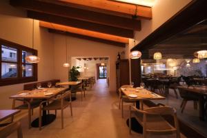 a restaurant with wooden tables and chairs in a room at Hotel Rural Es Riquers in Porreres