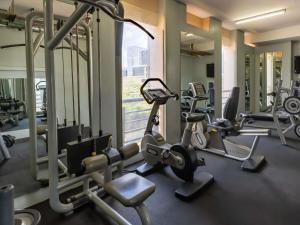 a gym with several tread machines and a window at Mercure Nairobi Upper Hill in Nairobi