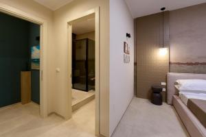 a bedroom with a door leading to a bathroom at Oltremare Luxury Suites in Otranto +36 photos
