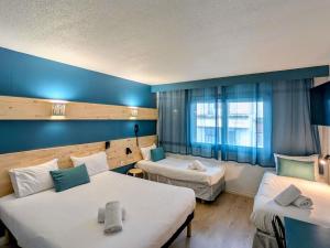 a hotel room with two beds and a window at greet Grenoble Centre Gare Accor Hotel in Grenoble