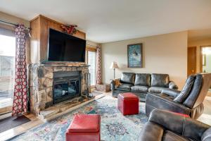 a living room with a fireplace with couches and a television at Silverthorne Condo: New Pool & Hot Tub + Fireplace in Silverthorne
