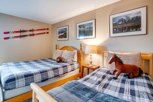 a bedroom with two beds and a toy horse on the bed at Silverthorne Condo: New Pool & Hot Tub + Fireplace in Silverthorne +22 photos