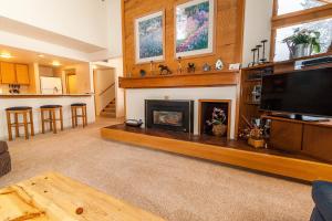 a living room with a fireplace and a flat screen tv at Quicksilver #1602 in Keystone