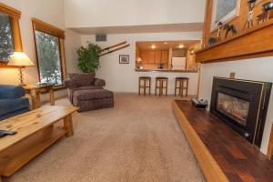 a living room with a fireplace and a kitchen at Quicksilver #1602 in Keystone