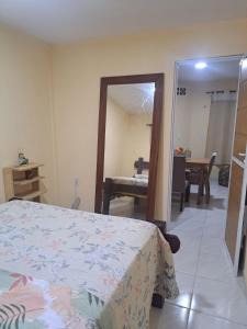 a bedroom with a bed and a large mirror at Kitnet Praia de Alagoinhas in Fortaleza