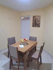 a dining room table with chairs and a bowl of fruit on it at Kitnet Praia de Alagoinhas in Fortaleza +5 photos