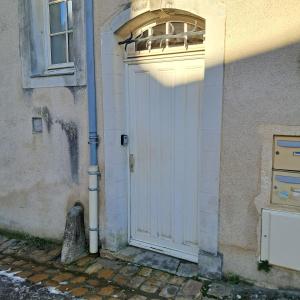a white door on the side of a building at le pomerol in Château-Gontier