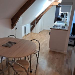 a kitchen and dining room with a wooden table at le pomerol in Château-Gontier +7 photos