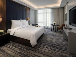 a hotel room with a large bed and a television at Movenpick Hotel and Residences Riyadh in Riyadh +148 photos