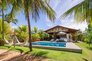 a villa with a swimming pool and a hammock at Casa Caroá - Chalé 3 in Japaratinga