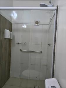 a bathroom with a glass shower with a toilet at Hotel Jacaré in Ituporanga