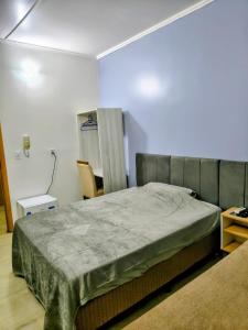 a bedroom with a bed and a chair in it at Hotel Jacaré in Ituporanga