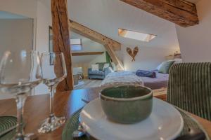 a table with a bowl on a plate with wine glasses at La grande Sure & Spa in Voiron