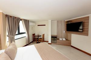 a hotel room with a bed and a flat screen tv at Hostal Los Cactus in Lima