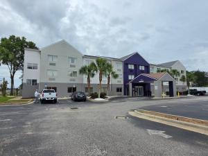 a large building with a parking lot in front of it at Sleep Inn & Suites Pensacola - University Area in Pensacola