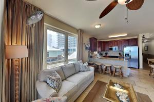 a living room with a couch and a kitchen at Beach Club #206A in Pensacola Beach