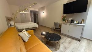 a living room with a couch and a bed at La Rose du Lac Hôtel Appart' in Coucouron