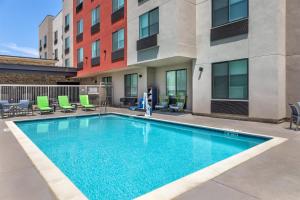 a swimming pool with chairs and a building at Best Western Plus Rialto in Rialto