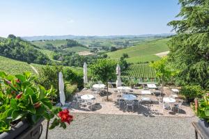 a patio with tables and chairs in a vineyard at Agriturismo Albarossa in Nizza Monferrato +66 photos