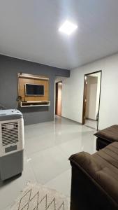 a living room with a couch and a microwave at Casa queen in Campo Grande