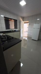 a kitchen with a stove and a counter top at Casa queen in Campo Grande