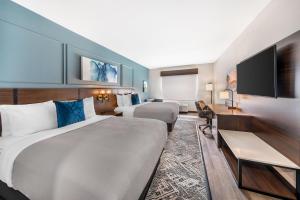 a hotel room with two beds and a flat screen tv at Best Western Plus Rialto in Rialto