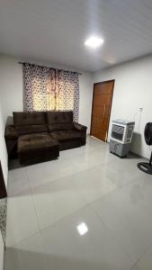 a living room with a couch and a television at Casa queen in Campo Grande