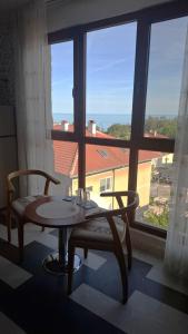 a table and two chairs in a room with a window at Magi Sunrise in Balchik