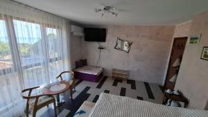 a room with a room with a table and a television at Magi Sunrise in Balchik