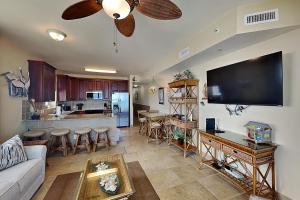 a living room with a couch and a kitchen at Beach Club #206A in Pensacola Beach