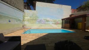 a swimming pool with a mural on the side of a building at Suíte Aconchegante com Hidromassagem Jardim Esplanada in São José dos Campos