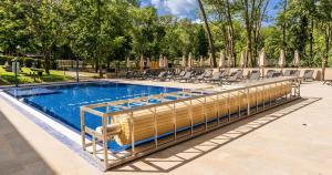 a large swimming pool with chairs and a pool at The Hotel Unforgettable - Hotel Tiliana by Homoky Hotels & Spa in Budapest