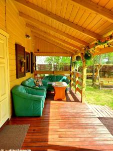 a porch with a couch and a table on a deck at TLdomki in Radęcin