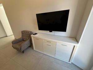 a living room with a tv and a chair at Apartment Dantéa Novéa - NEW 2026 in Izola