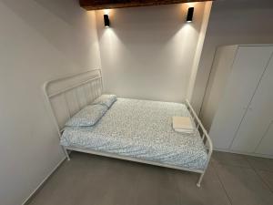 a small bed in a room with a white wall at Apartment Dantéa Novéa - NEW 2026 in Izola