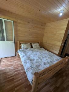 a bedroom with a bed in a wooden room at Guests house, Artani in Valbonë