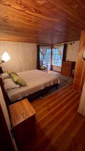 a bedroom with a bed in a room with wooden floors at Jazz House Pucon in Pucón