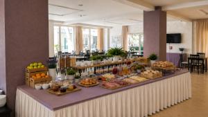 a buffet of food on a table in a room at Hotel Favorita Easy Stay B&B in Cesenatico