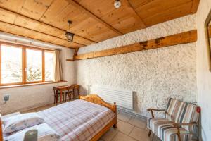 a bedroom with a bed and a chair and a window at Hôtel Von Bergen in La Sagne
