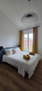 a bedroom with a large white bed with a window at Chez Mary in Larzicourt