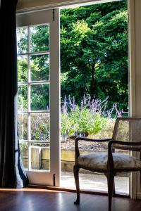 an open door with a chair in front of a window at Vibrant & Vintage B & B in Greenmount